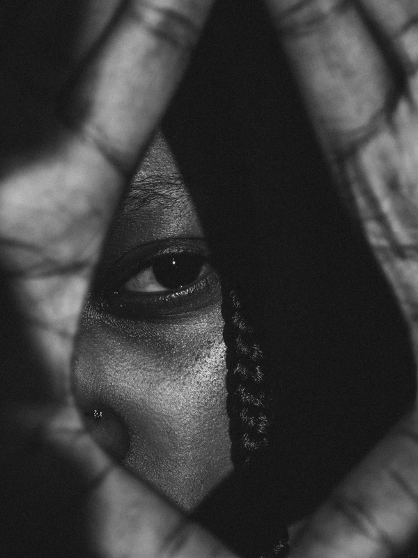 Un regard à travers le cadre formé par une main.